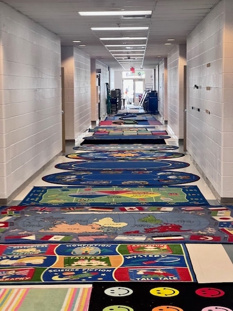 School hallway with colorful area rugs cleaned by Apex